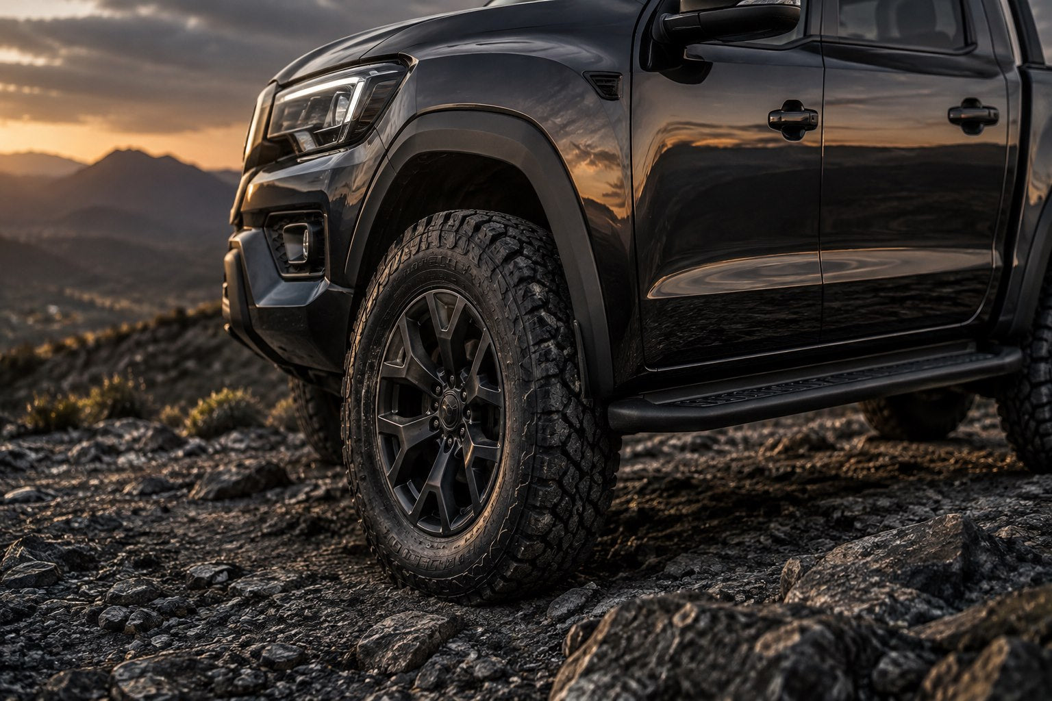 Close-up of a graphite bakkie’s wheel and sculpted bodywork at dusk